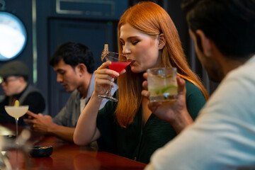 Group of Cheerful people friends celebrating holiday event hanging out party drinking alcoholic cocktail together at restaurant bar. Man and woman enjoy and fun hangout meeting nightlife at nightclub.