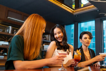 Group of Attractive woman enjoy and fun hangout nightlife meeting and drinking fancy cocktail together at luxury bar. Happy female friends celebrating holiday event party at nightclub in the city