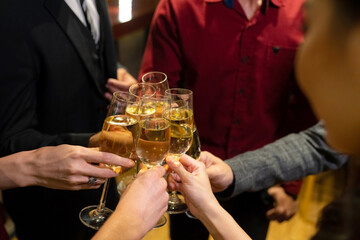 Group of Cheerful People celebrating holiday event party toasting champagne glass together at luxury restaurant bar. Happy man and woman friends enjoy and fun hangout meeting nightlife at nightclub