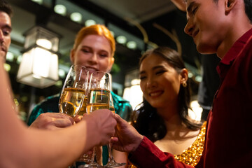Group of Cheerful People celebrating holiday event party toasting champagne glass together at luxury restaurant bar. Happy man and woman friends enjoy and fun hangout meeting nightlife at nightclub