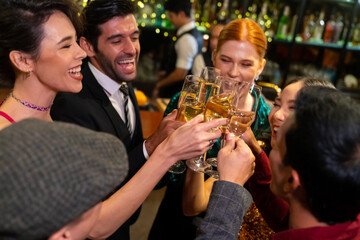 Group of Cheerful People celebrating holiday event party toasting champagne glass together at luxury restaurant bar. Happy man and woman friends enjoy and fun hangout meeting nightlife at nightclub