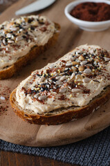 Hummus Toast with Rustic Bread, Vegetarian Snack or Breakfast on Wooden Background