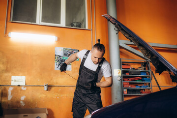 Fototapeta na wymiar Mechanic checking oil level in a car workshop