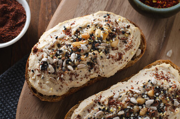 Hummus Toast with Rustic Bread, Vegetarian Snack or Breakfast on Wooden Background