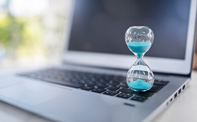 Hourglass on laptop computer concept for time management background - 614664738