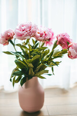 Delicate blooming pink peonies flowers in a vase