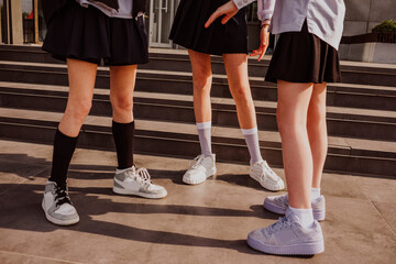 Female friends wearing shoes standing near steps
