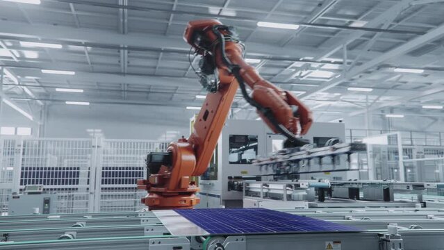 Orange Industrial Robot Arm Assembles Solar Panel, Placing PV Cells. Automated Solar Panel Production Line. Modern, Bright Manufacturing Facility.