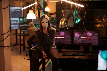 Anonymous hacking computer system, breaking into online server, attacking database. Cybercrime, woman hacker stealing information, programming malware software portrait at night time