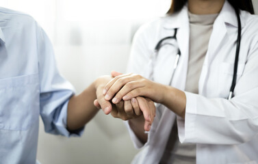 The female doctor uses a friendly hand to hold the patient's hand to give confidence and show care about health care. Medical concepts and good health