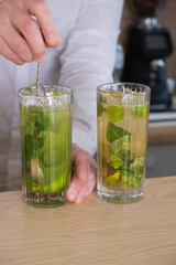 Preparation of a mojito cocktail by a bartender in a cafe. Summer cold drink