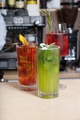 Alcoholic cocktails with ice in glasses on the bar counter. Summer drink at the bar