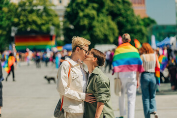 Loving lesbian couple kissing each other at gay pride event
