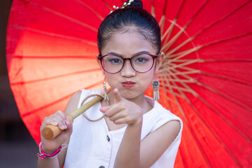 Portrait of an adorable cute Thai little girl of preschool age wearing Thai dress costume...
