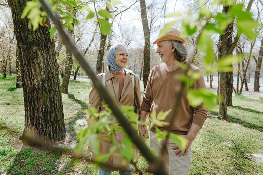 Couple enjoying leisure time walking amidst trees at park
