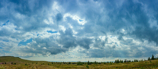 Sky panorama with light clouds on a summer day in a mountainous area. Sky background in high resolution