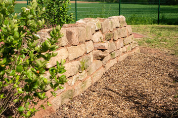self-built wall made of natural sandstone as a biotope