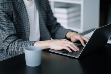 Male working on laptop keyboard at home office.