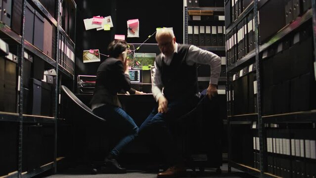 Officers finding criminal whereabouts, rushing to catch killer at secret illegal location. Law enforcement agents receiving criminal gps coordinates on landline phone call. Tripod shot.