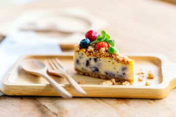 Appetizingly decorated cheesecakes on wooden plates, a popular dessert in cafe.