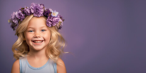 Fototapeta premium Adorable blond little girl wearing flowers in her hair. Isolated on purple background 