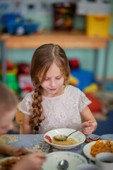 Kindergarten. Junior School. Lunch at the little schoolchildren. Little schoolchildren. Kindergarteners. Children. Friends. Studies. Food in the dining room. Soup. Fried cabbage. The children are havi
