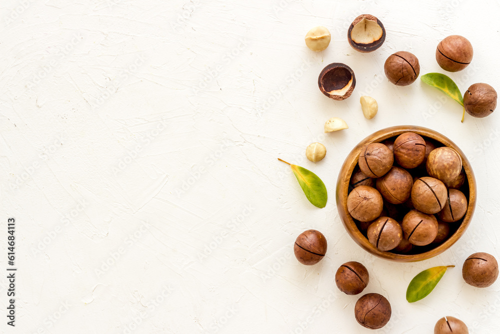 Wall mural Shelled macadamia nuts with green leaves. Healthy snack background - Wall murals