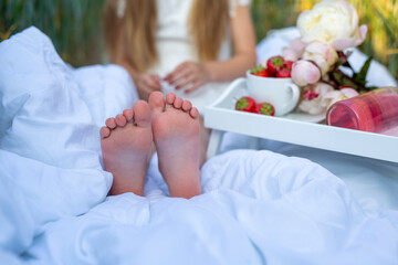Children's feet on a white blanket at a picnic