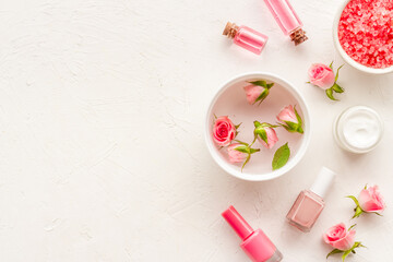 Pink roses cosmetic products set with flowers essential oil. Beauty care concept.