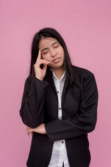 A young woman in a state of confusion, or suffering from a migraine after a long day. Isolated on a light pink background.