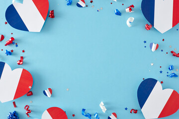 Concept of Bastille Day jubilation in France. Top view flat lay of hearts decorations in national colors and confetti on light blue background with empty space for promo or greeting