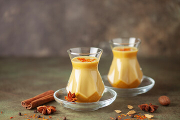 Golden Cinnamon  Turmeric Milk. Trendy hot Healthy drink with turmeric roots and spices. Indian...