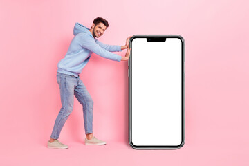 Full body length photo of young positive user smartphone promoter pushing empty space display app for dating isolated on pink color background