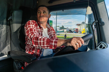 middle aged truck driver driving a cargo truck, dressed in casual clothes