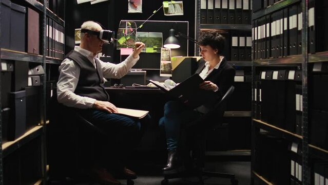 Senior inspector using vr glasses to reenact crime scene in police incident room, working on criminal case with agent. Male private investigator retracing killer steps with virtual reality headset.