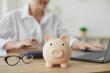 Piggy bank in form of pig on background of financial advisor who plans annual budget. Close up of...