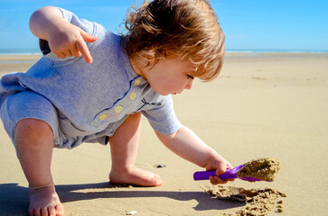 Pretty young girl discovering the fun of playing in the sand