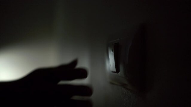 Earth Hour Close up woman finger turn off or on the light to saving electrical energy. Finger pushing light switch turn on or off. White switch.