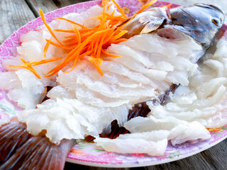 Tasty sashimi. Fresh and clean white fish arranged in the shape of the fish served on a plate...