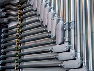 Wiring electric steel pipeline on concrete wall background. Steel tube fitting with electricity...
