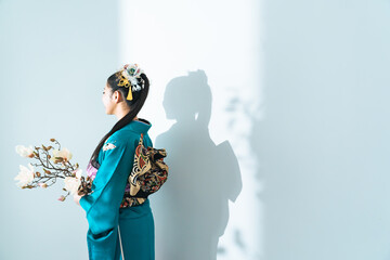 花を持つ振袖を着た女性のポートレート