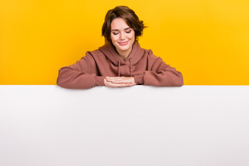 Photo of charming nice girl look down empty space advert blank isolated on yellow color background