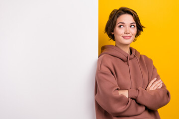 Portrait of crazy funky girl dressed brown sportswear look at white placard empty space arms crossed isolated on yellow color background - obrazy, fototapety, plakaty