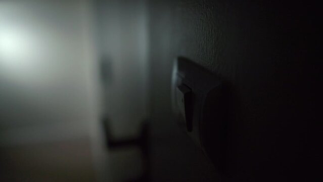 Earth Hour Close up woman finger turn off or on the light to saving electrical energy. Finger pushing light switch turn on or off. White switch.