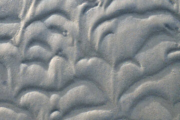 Structure in the sand made by waves. View on the ground at low tide. Nature photo