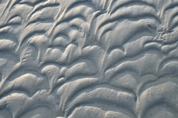 Structure in the sand made by waves. View on the ground at low tide. Nature photo