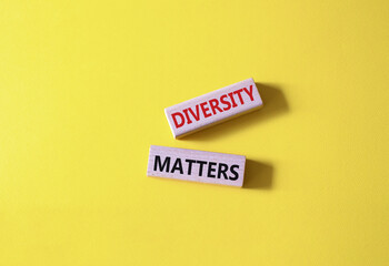 Diversity matters symbol. Wooden blocks with words Diversity matters. Beautiful yellow background. Business and Diversity matters concept. Copy space.