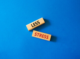 Less stress symbol. Wooden blocks with words Less stress. Beautiful blue background. Healthcare and Less stress concept. Copy space.