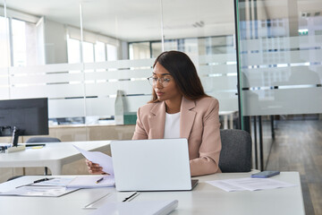 Busy serious young African American business woman, account manager executive checking tax bills...