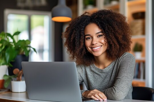 Working From The Comfort Of Her Home, A Black Woman With A Radiant Smile Focuses On Her Computer, Embracing The Freedom Of Remote Work.